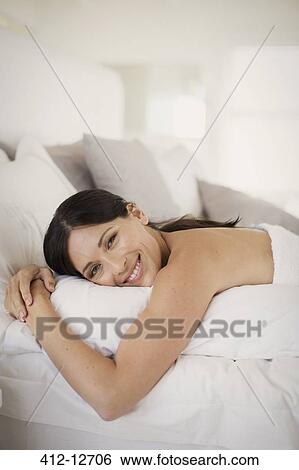 Woman hugging pillow on bed View Large Photo Image Stock Photograph - Woman hugging pillow on bed. Fotosearch
