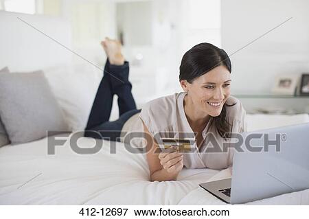Stock Photo - Woman shopping online with laptop. Fotosearch
