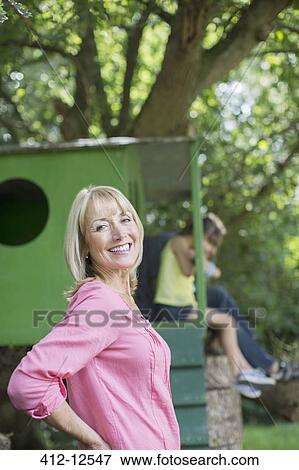Woman smiling with treehouse in background View Large Photo Image Stock Photo - Woman smiling with treehouse in background. Fotosearch