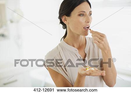 Stock Image - Woman taking pills. Fotosearch