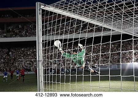 Stock Image - Goalie defending soccer net on field. Fotosearch