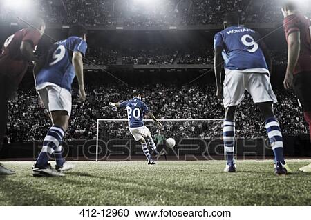 Stock Image - Soccer player kicking ball at goal. Fotosearch
