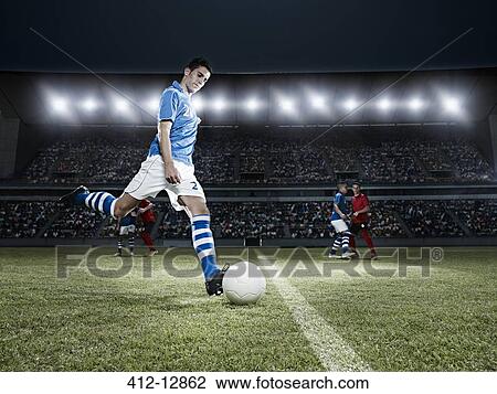 Soccer player kicking ball on field View Large Photo Image Stock Image - Soccer player kicking ball on field. Fotosearch