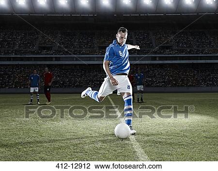 Soccer player kicking ball on field View Large Photo Image Stock Image - Soccer player kicking ball on field. Fotosearch