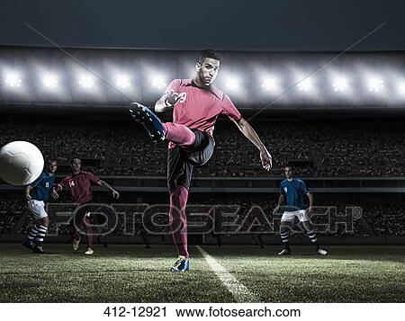 Soccer player kicking ball on field View Large Photo Image Stock Image - Soccer player kicking ball on field. Fotosearch