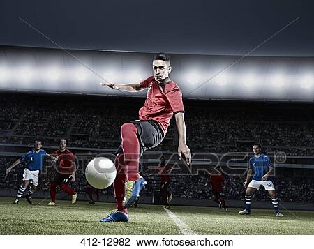 Soccer player kicking ball on field View Large Photo Image Stock Image - Soccer player kicking ball on field. Fotosearch