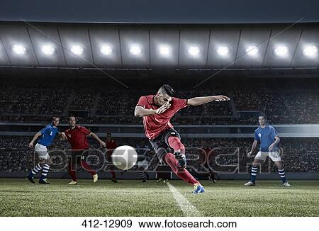Stock Photo - Soccer player kicking ball on field. Fotosearch