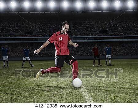 Soccer player kicking ball on field View Large Photo Image Stock Photography - Soccer player kicking ball on field. Fotosearch