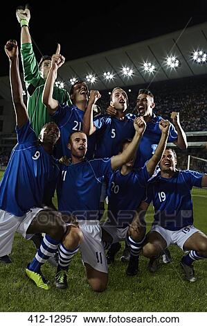 Soccer players cheering on field View Large Photo Image Stock Photo - Soccer players cheering on field. Fotosearch