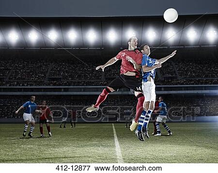 Soccer players jumping for ball on field View Large Photo Image Stock Photo - Soccer players jumping for ball on field. Fotosearch