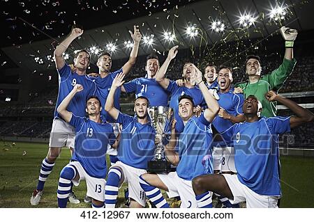 Soccer team cheering with trophy on field View Large Photo Image Stock Photo - Soccer team cheering with trophy on field. Fotosearch