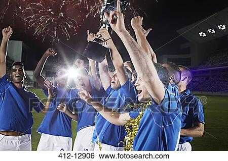 Soccer team cheering with trophy on field View Large Photo Image Stock Photograph - Soccer team cheering with trophy on field. Fotosearch