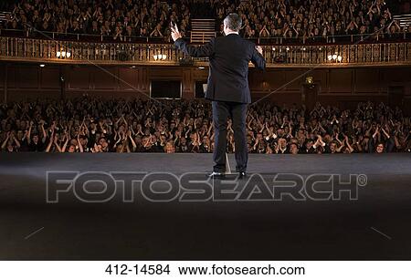 Picture - Audience clapping for conductor on stage in theater. Fotosearch