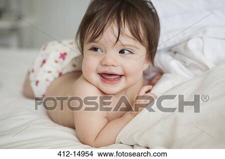 Baby girl laying in bedsheets View Large Photo Image Picture - Baby girl laying in bedsheets. Fotosearch