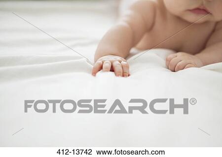 Baby girl laying on bed View Large Photo Image Stock Image - Baby girl laying on bed. Fotosearch