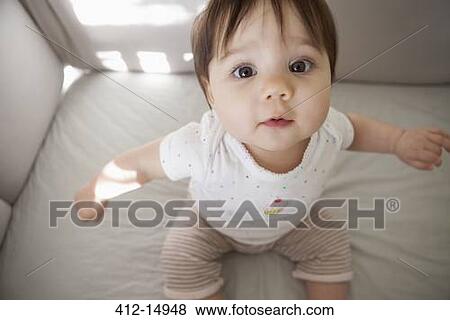 Baby girl sitting up in crib View Large Photo Image Stock Photo - Baby girl sitting up in crib. Fotosearch