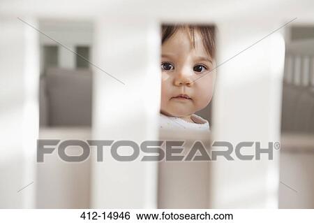 Baby girl sitting up in crib View Large Photo Image Stock Photograph - Baby girl sitting up in crib. Fotosearch