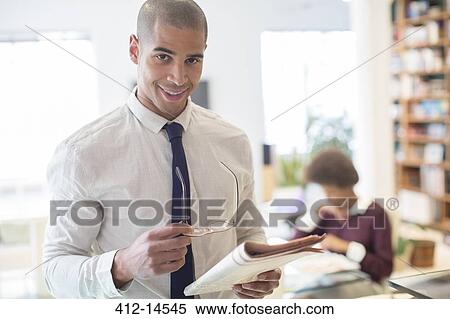 Businessman reading newspaper in living room View Large Photo Image Stock Photography - Businessman reading newspaper in living room. Fotosearch