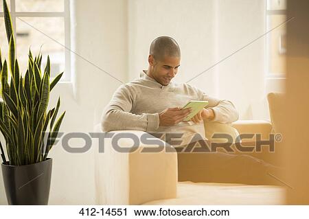 Businessman using digital tablet on sofa View Large Photo Image Stock Image - Businessman using digital tablet on sofa. Fotosearch