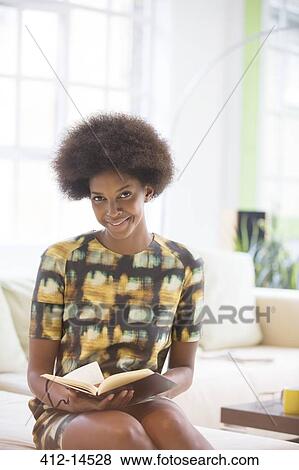 Stock Photo - Businesswoman reading book on sofa. Fotosearch