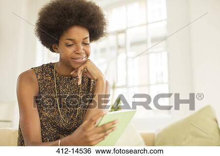 Businesswoman using digital tablet on sofa View Large Photo Image Stock Photograph - Businesswoman using digital tablet on sofa. Fotosearch