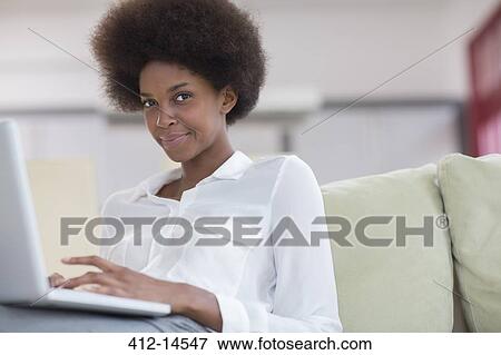 Businesswoman using laptop on sofa View Large Photo Image Stock Photo - Businesswoman using laptop on sofa. Fotosearch