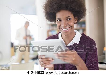 Businesswoman using tablet in living room View Large Photo Image Stock Image - Businesswoman using tablet in living room. Fotosearch