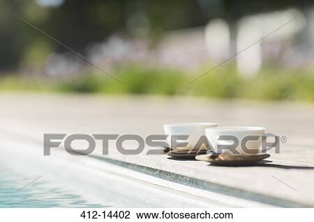 Stock Image - Cappuccino cups at poolside. Fotosearch