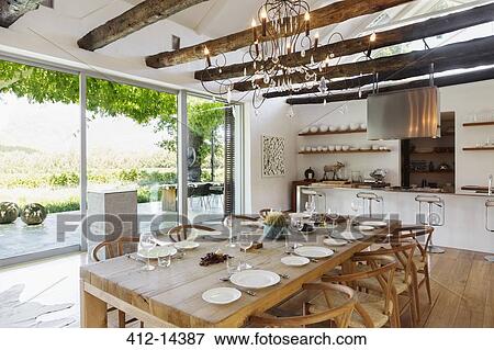 Chandelier over dining table in modern house View Large Photo Image Stock Photo - Chandelier over dining table in modern house. Fotosearch