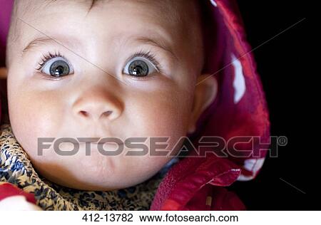 Stock Image - Close up of baby girl's surprised face. Fotosearch