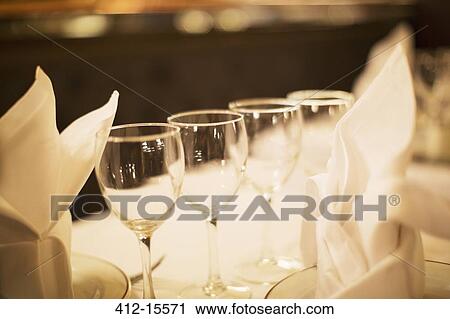 Stock Image - Close up of wine glasses on restaurant table. Fotosearch
