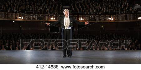 Stock Photo - Conductor performing on stage in theater. Fotosearch