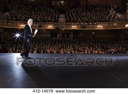 Stock Photo - Conductor walking onto stage in theater. Fotosearch
