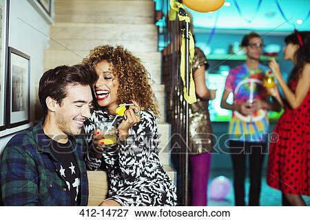 Stock Photo - Couple laughing at party. Fotosearch