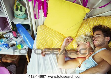 Stock Photo - Couple sleeping in bed after party. Fotosearch