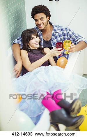 Couple toasting each other in bathtub at party View Large Photo Image Stock Image - Couple toasting each other in bathtub at party. Fotosearch