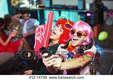 Couple wearing costumes at party View Large Photo Image Stock Photo - Couple wearing costumes at party. Fotosearch