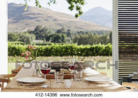 Dining table and chairs on luxury patio overlooking vineyard View Large Photo Image Stock Photograph - Dining table and chairs on luxury patio overlooking vineyard. Fotosearch