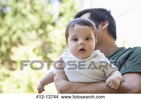 Picture - Father carrying baby girl outdoors. Fotosearch