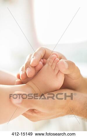 Father cradling baby boy's feet View Large Photo Image Stock Photo - Father cradling baby boy's feet. Fotosearch