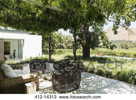 Stock Image - Fire pit and armchairs on luxury patio overlooking vineyard. Fotosearch