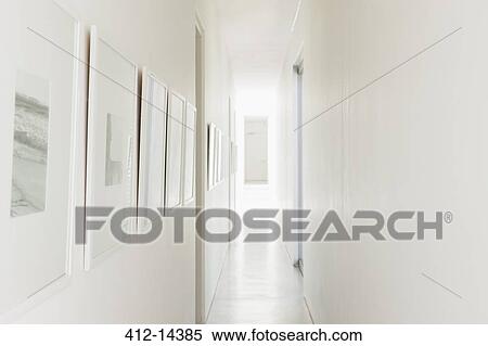 Stock Photography - Framed photographs hanging on white corridor walls. Fotosearch