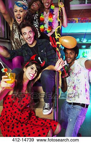 Friends cheering together at party View Large Photo Image Stock Photo - Friends cheering together at party. Fotosearch