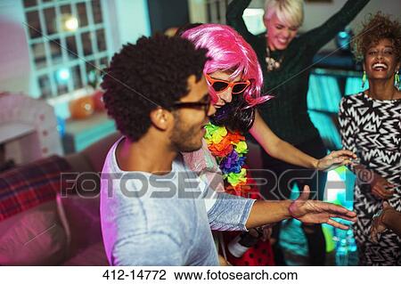 Stock Image - Friends dancing together at party. Fotosearch