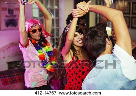 Stock Photo - Friends dancing together at party. Fotosearch