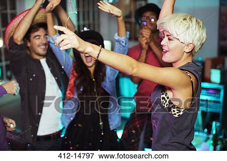 Stock Photo - Friends dancing together at party. Fotosearch