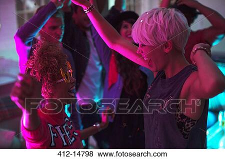 Stock Photo - Friends dancing together at party. Fotosearch