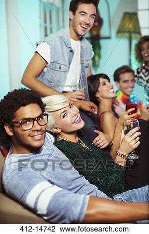 Friends drinking on sofa at party View Large Photo Image Stock Image - Friends drinking on sofa at party. Fotosearch