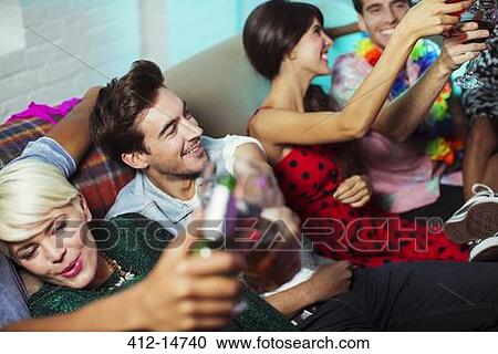 Friends on sofa at party View Large Photo Image Stock Image - Friends on sofa at party. Fotosearch