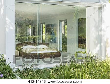 Stock Photograph - Grass outside window of modern bedroom. Fotosearch